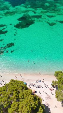 Playa de Formentor 'un Mallorca' daki Cala Pi de la Posada körfezindeki hava manzarası. Cap Formentor, Mayorka, Balear Adaları, İspanya 'da turkuaz sularda yüzen insanların olduğu çarpıcı bir sahil..