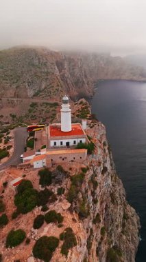 Kuzey Mallorca, Balear Adaları, İspanya 'daki Cape Formentor' daki pitoresk deniz fenerinin hava manzarası. Güzel, dolambaçlı bir yol, denizin üzerindeki yüksek bir uçuruma tünemiş deniz fenerine çıkar..