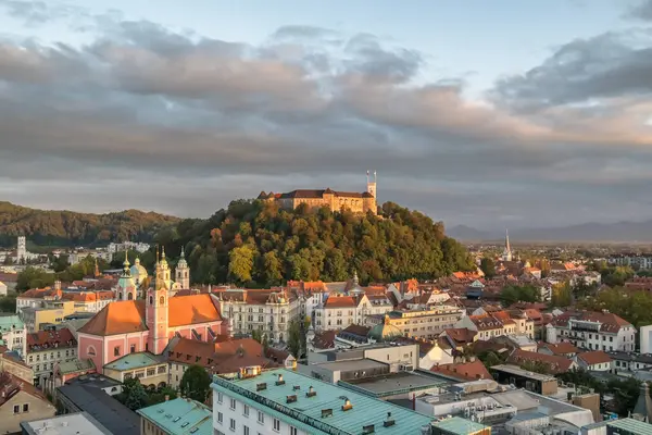 Slovenya 'da gün batımında Ljubljana şehir manzarasının en üst görüntüsü. Ljubljana Şatosu, Sloven başkentinin tarihi binalarına tepeden bakıyor..