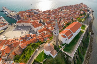 Tarihi bir deniz feneri ve turkuaz deniz manzaralı Piran 'ın Slovenya' daki eski kenti. Zengin tarihi ve çarpıcı manzarası olan pitoresk bir Akdeniz kıyısı mücevheri.