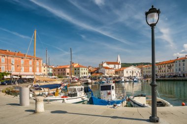 Slovenya 'nın Istria bölgesindeki Adriyatik kıyısındaki Picturesque Izola kasabası. Arka planda balıkçı tekneleri ve ortaçağ binaları olan büyüleyici bir liman.