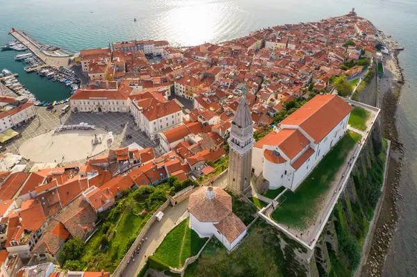 Tarihi bir deniz feneri ve turkuaz deniz manzaralı Piran 'ın Slovenya' daki eski kenti. Zengin tarihi ve çarpıcı manzarası olan pitoresk bir Akdeniz kıyısı mücevheri.