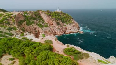 İspanya, Balearic Adaları, Mallorca 'daki Faro Capdepera deniz fenerinin hava manzarası. Manzaralı deniz feneri, Mayorka adasındaki Akdeniz manzaralı yüksek bir uçuruma tünemişti..