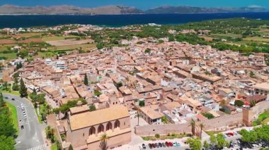 İspanya 'nın Balear Adaları' ndaki güneşli bir günde Mallorca 'nın güzel Alcudia kasabasının hava manzarası. St. Jaume Kilisesi ve Mayorka adasındaki diğer tarihi binalar.