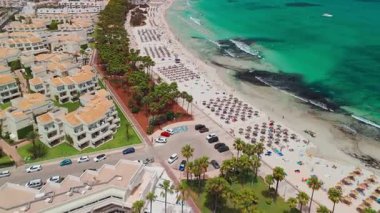 İspanya, Balearic Adaları, Mallorca 'daki Platja de sa Coma plajının havadan görüntüsü. Turkuaz suları olan büyüleyici beyaz kumsal yaz boyunca Mayorka adasında güzel bir tatil köyü ile çevrili..