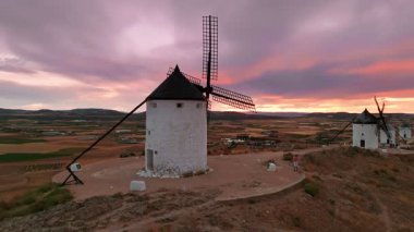 Günbatımında Consuegra 'nın tarihi yel değirmenlerinin havadan görünüşü, Castilla-La Mancha, İspanya. Akşam ışığında tepelerde Don Kişot 'un eski tarihi yel değirmenleri. Molinos de Viento de Consuegra
