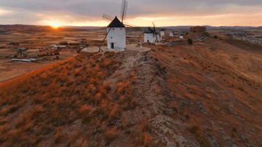 Günbatımında Consuegra 'nın tarihi yel değirmenlerinin havadan görünüşü, Castilla-La Mancha, İspanya. Akşam ışığında tepelerde Don Kişot 'un eski tarihi yel değirmenleri. Molinos de Viento de Consuegra