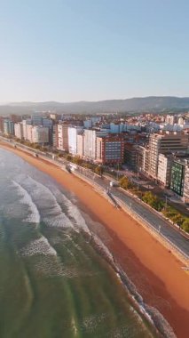 Gündoğumunda Gijon 'daki Playa de San Lorenzo plajının havadan görünüşü, Asturias, İspanya. Büyüleyici sahil, Cantabrian Denizi kıyısındaki sahil kasabasının manzaralı manzarasıyla sabah güneşiyle yıkandı.