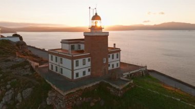 Güneş doğarken Cape Finisterre 'deki Faro de Fisterra deniz fenerinin havadan görünüşü, Costa de la Muerte, Galiçya, kuzey İspanya. Camino de Santiago hac yolunun son durağı.