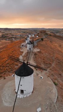 Günbatımında Consuegra 'nın tarihi yel değirmenlerinin havadan görünüşü, Castilla-La Mancha, İspanya. Akşam ışığında tepelerde Don Kişot 'un eski tarihi yel değirmenleri. Molinos de Viento de Consuegra