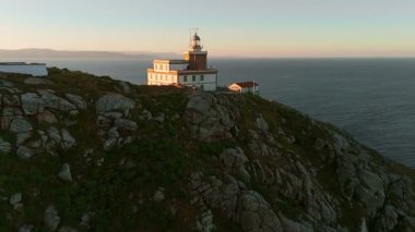 Güneş doğarken Cape Finisterre 'deki Faro de Fisterra deniz fenerinin havadan görünüşü, Costa de la Muerte, Galiçya, kuzey İspanya. Camino de Santiago hac yolunun son durağı.