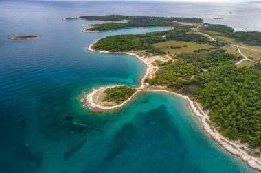 Hırvatistan 'ın Istria bölgesinin Pula kenti yakınlarındaki Adriyatik Denizi kayalık kıyılarının hava manzarası. Adriyatik Denizi 'nin güzel suları Hırvatistan' da inanılmaz mavi ve turkuaz renklerle