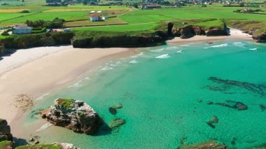 İspanya 'nın Galiçya kentindeki Cantabrian Denizi kıyısının hava manzarası. Yeşil çayırlar, yüksek uçurumlar, beyaz kumsallar ve turkuaz sular. Atlantik kıyısında manzaralı bir kıyı yolu var..