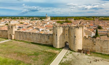 Güneşli bir günde, Fransa 'nın güneyindeki Camargue bölgesinde, pembe tuz gölü yakınlarındaki ortaçağ duvarlı Aigues-Mortes kasabasının havadan görünüşü.