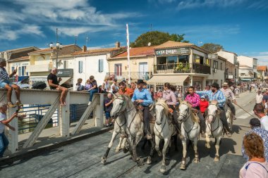 Le Grau-du-Roi, Fransa - 11 Eylül 2024: Course Camarguaise, Fransa 'nın güneyindeki Camargue bölgesinde düzenlenen geleneksel bir boğa güreşi etkinliği. At sırtındaki muhafızlar bir boğaya arenaya kadar eşlik etsin.