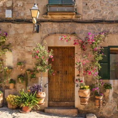 İspanya 'nın Balearic Adaları, Mallorca, Valdemossa kentindeki çiçek saksılarıyla büyüleyici bir ev girişi. Geleneksel Akdeniz tarzı mimari.