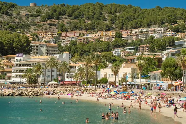 Port de Soller, İspanya - 13 Haziran 2024: İspanya 'nın Balearic Adaları, Mallorca' daki Port de Soller tatil beldesindeki güzel plaj. İçinde demirli yatlar olan cennet turkuaz bir göl. Mayorka, İspanya.