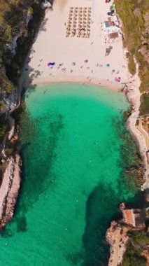 İspanya 'nın Balearic Adaları, Mallorca' daki Cala Llombards plajının yukarıdan görünüşü. Turkuaz su limanı ve beyaz kumsal sahili ile Akdeniz kıyılarını sersemletiyor. Mallorca seyahat noktaları