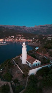 İspanya 'nın Balearic Adaları, Mallorca' daki Port de Soller tatil köyü ile birlikte gece Faro de Cabo Gordo deniz fenerinin hava görüntüsü. Soller Körfezi girişinde tarihi deniz feneri, Mayorka