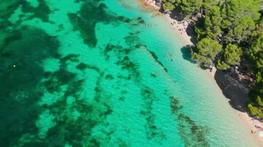 Playa de Formentor 'un Mallorca' daki Cala Pi de la Posada körfezindeki hava manzarası. Cap Formentor, Mayorka, Balear Adaları, İspanya 'da turkuaz sularda yüzen insanların olduğu çarpıcı bir sahil..