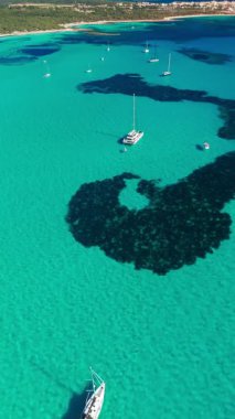 İspanya 'nın Balear Adaları, Mallorca' daki çarpıcı Akdeniz kıyılarının hava manzarası. Mallorca adasının turkuaz sularında huzur içinde demirlemiş yelkenliler..