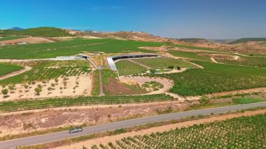 La Rioja, İspanya - 17 Ağustos 2024: İspanya 'nın La Rioja kentindeki güzel üzüm bağlarıyla çevrili Bodegas Beronia şaraphanesinin havadan görünüşü. Kuzey İspanya 'da ünlü Rioja şarabı üretimi.