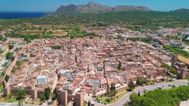 İspanya 'nın Balear Adaları' ndaki güneşli bir günde Mallorca 'nın güzel Alcudia kasabasının hava manzarası. St. Jaume Kilisesi ve Mayorka adasındaki diğer tarihi binalar.