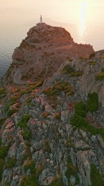 İspanya 'nın Balearic Adaları, Mallorca, Cape Formentor' daki pitoresk deniz fenerinin hava görüntüsü. Güzel, dolambaçlı bir yol, denizin üzerindeki yüksek bir uçuruma tünemiş deniz fenerine çıkar.
