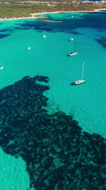 İspanya 'nın Balear Adaları, Mallorca' daki çarpıcı Akdeniz kıyılarının hava manzarası. Mallorca adasının turkuaz sularında huzur içinde demirlemiş yelkenliler..