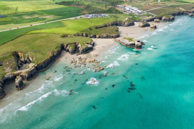 İspanya 'nın Galiçya kentindeki Cantabrian Denizi kıyısının hava manzarası. Yeşil çayırlar, yüksek uçurumlar, beyaz kumsallar ve turkuaz sular. Atlantik kıyısında manzaralı bir kıyı yolu var..