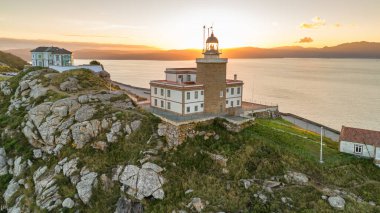 Güneş doğarken Cape Finisterre 'deki Faro de Fisterra deniz fenerinin havadan görünüşü, Costa de la Muerte, Galiçya, kuzey İspanya. Camino de Santiago hac yolunun son durağı.