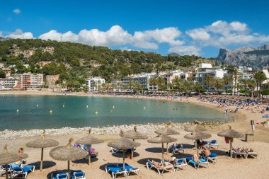 Port de Soller, İspanya - 13 Haziran 2024: İspanya 'nın Balearic Adaları, Mallorca' daki Port de Soller tatil beldesindeki güzel plaj. İçinde demirli yatlar olan cennet turkuaz bir göl. Mayorka, İspanya.