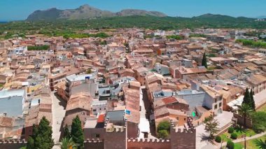 İspanya 'nın Balear Adaları' ndaki güneşli bir günde Mallorca 'nın güzel Alcudia kasabasının hava manzarası. St. Jaume Kilisesi ve Mayorka adasındaki diğer tarihi binalar.
