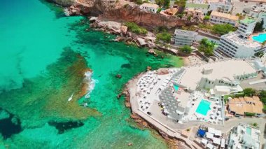 İspanya, Balearic Adaları, Mallorca 'daki Cala Sant Vicent tatil köyünün havadan görüntüsü. Turkuaz suları olan çarpıcı kumlu sahil, Mayorka adasında popüler bir tatil beldesi..