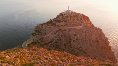 İspanya 'nın Balearic Adaları, Mallorca, Cape Formentor' daki pitoresk deniz fenerinin hava görüntüsü. Güzel, dolambaçlı bir yol, denizin üzerindeki yüksek bir uçuruma tünemiş deniz fenerine çıkar.