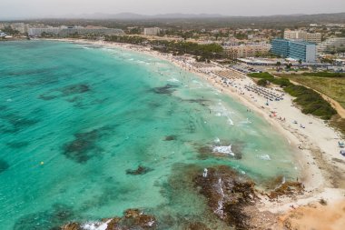İspanya, Balearic Adaları, Mallorca 'daki Platja de sa Coma plajının havadan görüntüsü. Turkuaz suları olan büyüleyici beyaz kumsal yaz boyunca Mayorka adasında güzel bir tatil köyü ile çevrili..