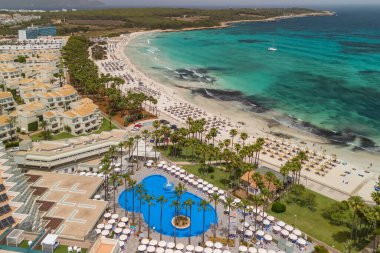 İspanya, Balearic Adaları, Mallorca 'daki Platja de sa Coma plajının havadan görüntüsü. Turkuaz suları olan büyüleyici beyaz kumsal yaz boyunca Mayorka adasında güzel bir tatil köyü ile çevrili..