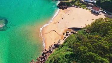 Gijon, Asturias yakınlarındaki inanılmaz Playa de La Nora plajı, kuzey İspanya. Asturias 'ın Cantabrian Denizi kıyısı boyunca turkuaz deniz suyuyla cennet gibi beyaz kumsal manzarası..