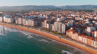Gündoğumunda Gijon 'daki Playa de San Lorenzo plajının havadan görünüşü, Asturias, İspanya. Büyüleyici sahil, Cantabrian Denizi kıyısındaki sahil kasabasının manzaralı manzarasıyla sabah güneşiyle yıkandı.