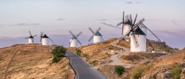 Consuegra 'nın tarihi yel değirmenlerinin güneş doğuşundaki manzarası, Castilla-La Mancha, İspanya. Akşam ışığında tepelerde Don Kişot karakterinin tarihi yel değirmenleri. Molinos de Viento de Consuegra