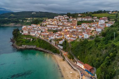 İspanya 'nın kuzeyinde, Alacakaranlık' taki Asturias bölgesindeki büyüleyici balıkçı köyü Lastres 'in hava manzarası. Biscay Körfezi 'ne bakan bir yamaçta kurulmuş güzel bir sahil kasabası..