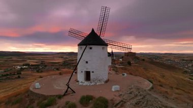 Günbatımında Consuegra 'nın tarihi yel değirmenlerinin havadan görünüşü, Castilla-La Mancha, İspanya. Akşam ışığında tepelerde Don Kişot 'un eski tarihi yel değirmenleri. Molinos de Viento de Consuegra