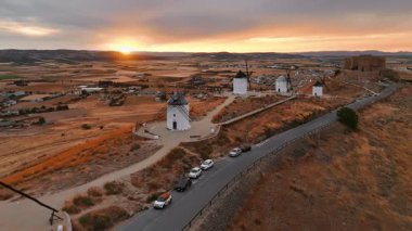Günbatımında Consuegra 'nın tarihi yel değirmenlerinin havadan görünüşü, Castilla-La Mancha, İspanya. Akşam ışığında tepelerde Don Kişot 'un eski tarihi yel değirmenleri. Molinos de Viento de Consuegra