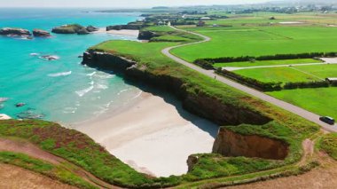 İspanya 'nın Galiçya kentindeki Cantabrian Denizi kıyısının hava manzarası. Yeşil çayırlar, yüksek uçurumlar, beyaz kumsallar ve turkuaz sular. Atlantik kıyısında manzaralı bir kıyı yolu var..