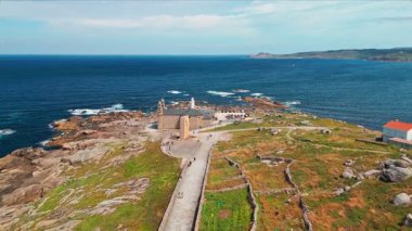 Santuario da Virxe da Barca, Faro de Muxia deniz feneri ve Mirador Jesus Quintanal 'ın Galiçya, İspanya' daki engebeli Costa da Morte boyunca havadan görünüşü. Camino de Santiago 'da popüler bir yer.