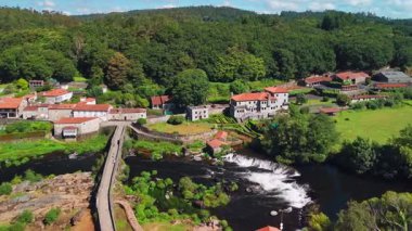İspanya, Galiçya 'daki Camino de Santiago hac rotasındaki Ponte Maceira köyünün hava manzarası. Tarihi bir Roma köprüsü ve sakin bir kırsal alanda büyüleyici taş evler.