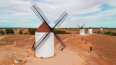İspanya, Castilla-La Mancha 'daki Mota del Cuervo' nun tarihi yel değirmenlerinin hava manzarası. Akşam ışığında tepelerde Don Kişot 'un eski tarihi yel değirmenleri. Molinos de Viento de Mota del Cuervo