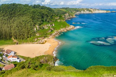 Gijon, Asturias yakınlarındaki inanılmaz Playa de La Nora plajı, kuzey İspanya. Asturias 'ın Cantabrian Denizi kıyısı boyunca turkuaz deniz suyuyla cennet gibi beyaz kumsal manzarası..