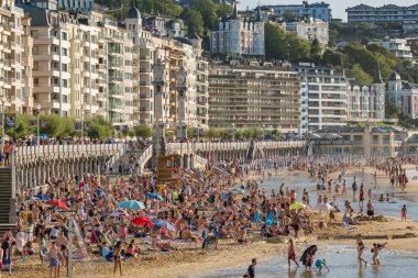 Donostia, İspanya - 21 Ağustos 2024: San Sebastian veya Donostia şehrinde turkuaz suları olan La Concha Sahili, İspanya, Bask Bölgesi, yaz boyunca. Kuzey İspanya 'da güzel bir yaz tatili