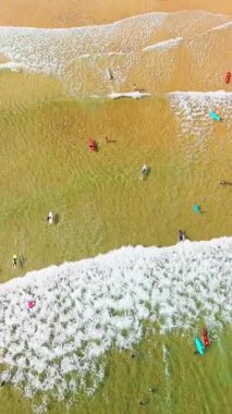 Güzel Bakio Hondartza plajı Bentalde, Bakio, Bask Ülkesi, İspanya. Bir grup sörfçü Kuzey İspanya 'daki çarpıcı kumsalda dalgaları yakalıyor.